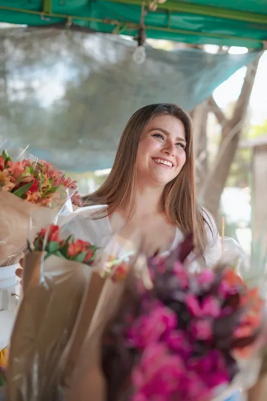 Clienta sonriente en un puesto de flores