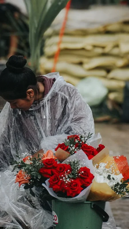Vendedora preparando ramos de rosas rojas